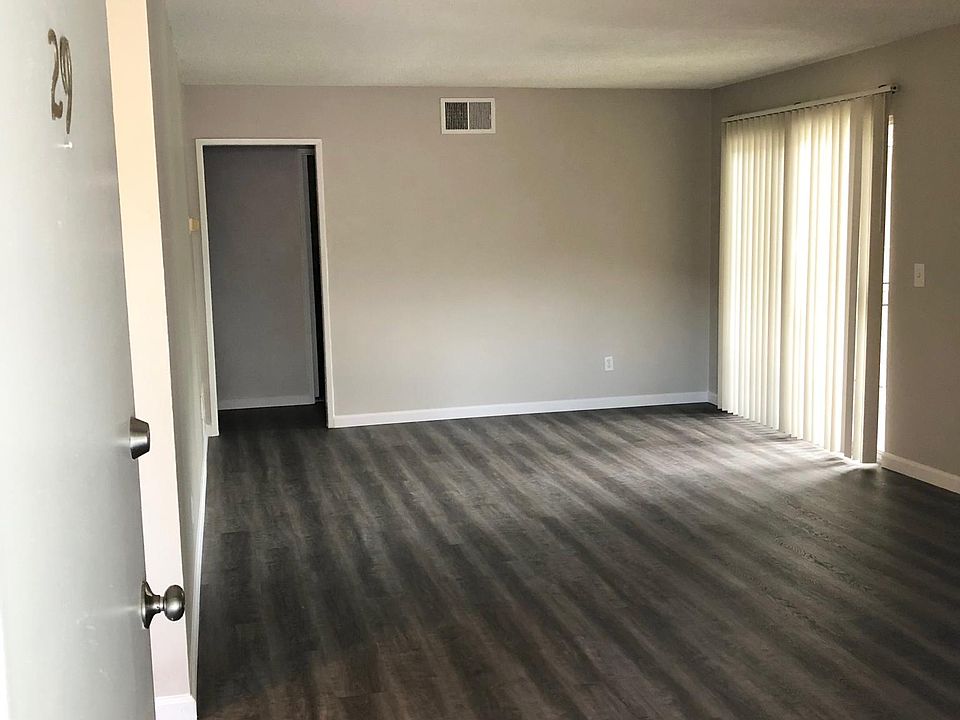 Spacious living room with brand new wood patterned grey flooring .