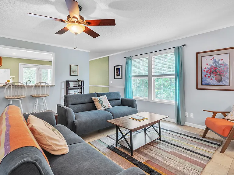The living room gets nice natural light in addition to the light and ceiling fan.