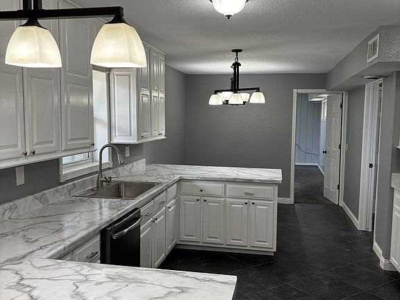 Kitchen overlooking dining area with dishwasher, new wide sink, new countertops, and tall cabinets