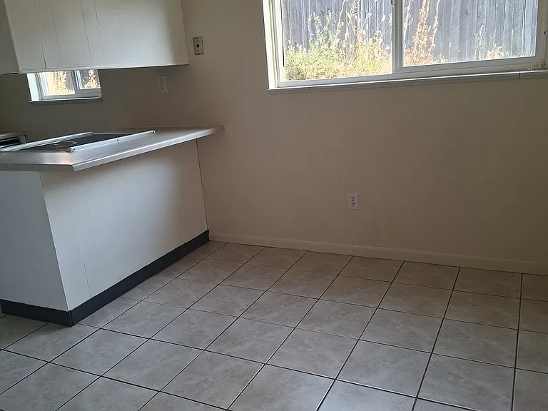The Dining room with tile floor, facing kitchen to the left.