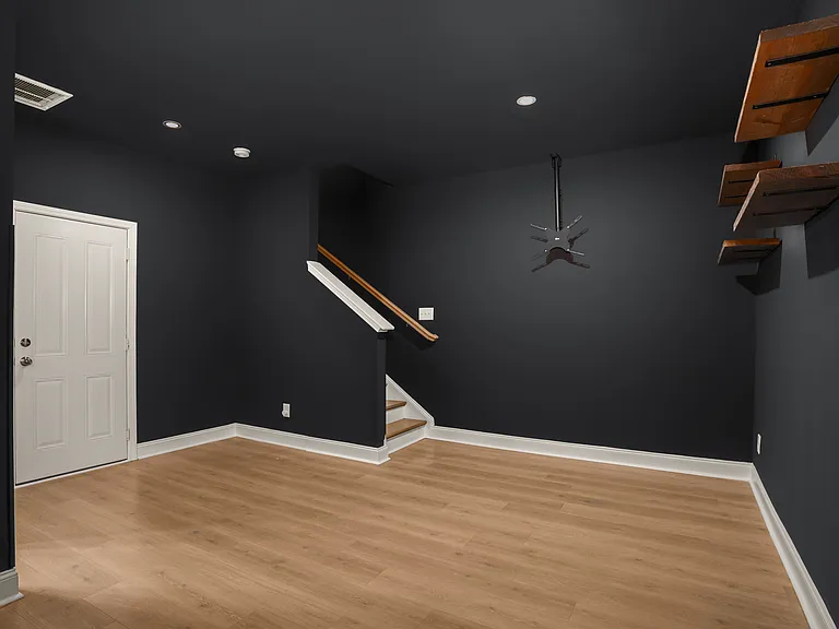 Media room set up with hardwood flooring and 2 car garage access