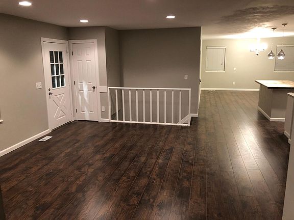 Front door and main floor living room with stairs to basement.