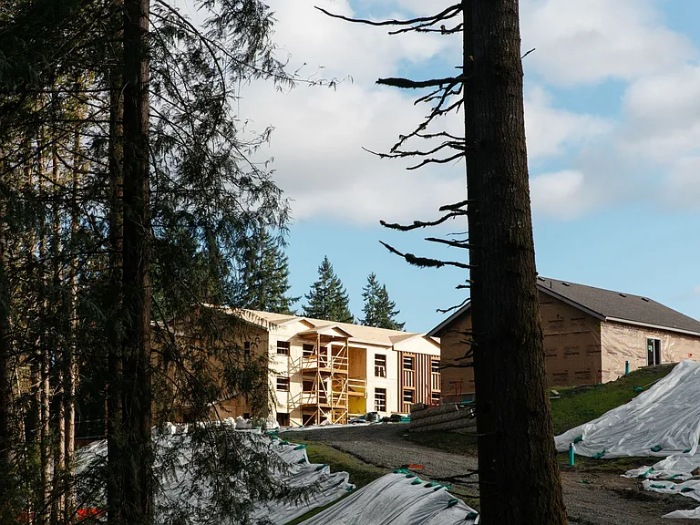 The Elowen under construction in Lacey, WA. New apartment homes taking shape among the tall evergreen trees that define the Pacific Northwest landscape.