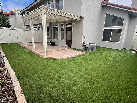 Low maintenance yard with patio cover and artificial turf
