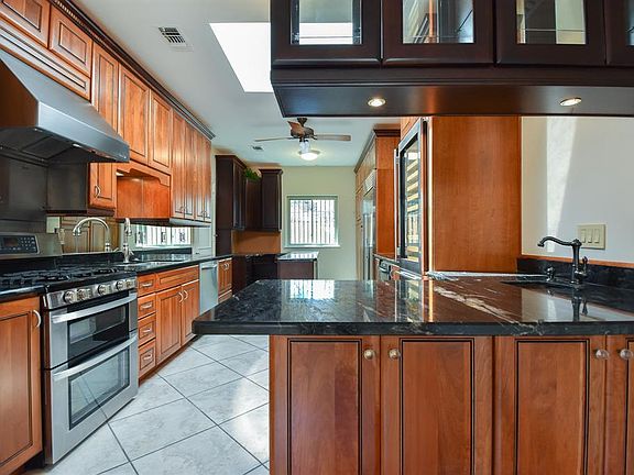 Another angle of the kitchen spotlighting the wet bar and the far corner kitchen computer station. Top of the line appliances, Sub Zero side by side refrigerator-freezer with water and ice maker, 2 zone wine cooler, 3 drawer Kitchen Aid dish washer, 