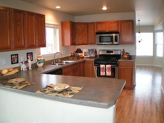 Open kitchen with new appliances, hardwood floors and breakfast bar.
