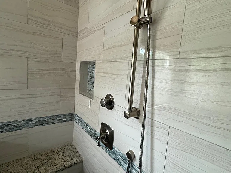 Two shower heads, one is a sprayer. Tub also has a sprayer.