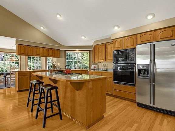 Generous cook's kitchen with granite counters, large island with gas cook top, stainless steel refrigerator and an abundance of cabinets.