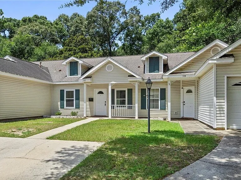 Siding exterior with dormer windows, covered front porch, and an attached single-car garage