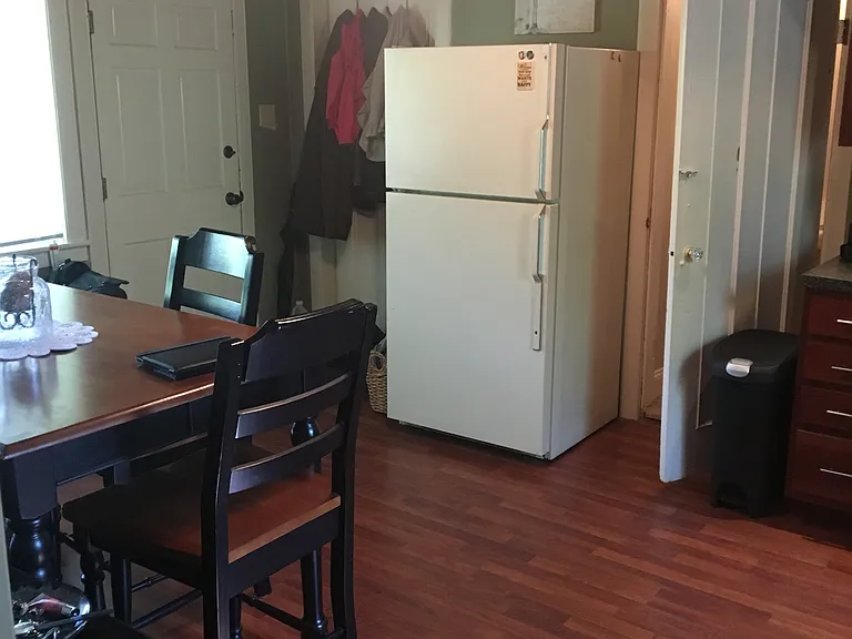 Livingroom shown with previous tenants furniture & different fridge position