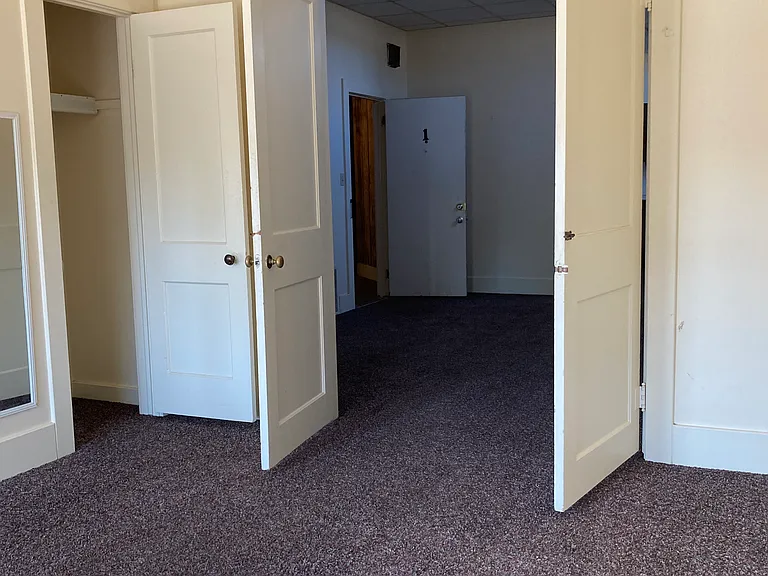 Master bedroom looking back in to the living room and apartment entrance.