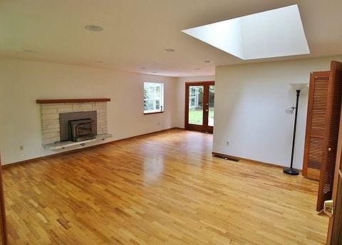 Living room with french doors, fireplace, and skylight