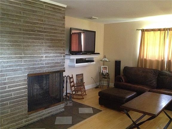 Wood burning fireplace in stone mantle surround. Neutral paint throughout.
