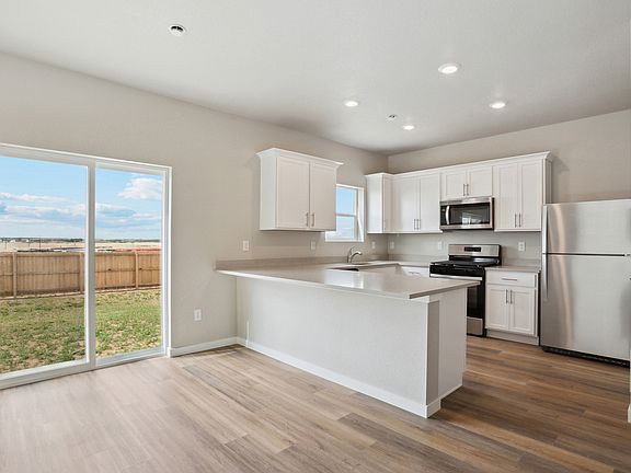 The kitchen has stainless steel appliances and white cabinets
