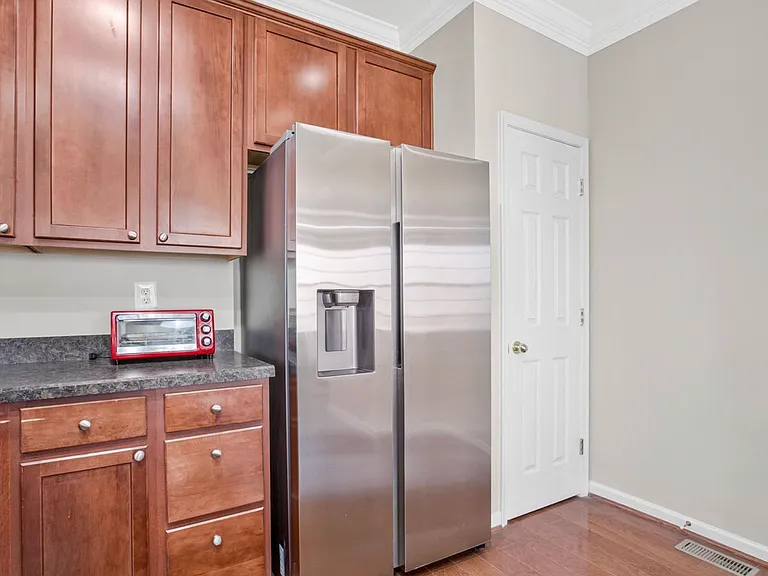 Clean lines, rich wood cabinetry, granite countertops, and stainless steel appliances give this kitchen a polished, modern feel with plenty of warmth.