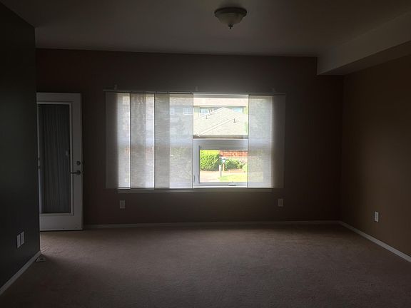 View from the kitchen. Door leads to patio. See a clubhouse and landscaped view through window.