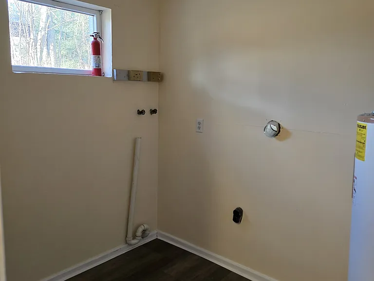 Laundry room showing appliance hookup and water heater. Circuit breaker is on the wall to the left