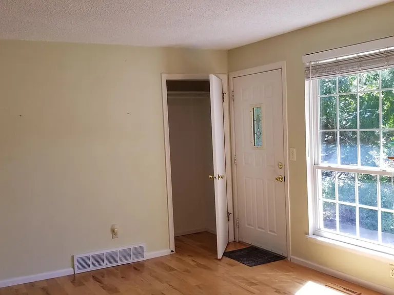 Living room with closet and front door.