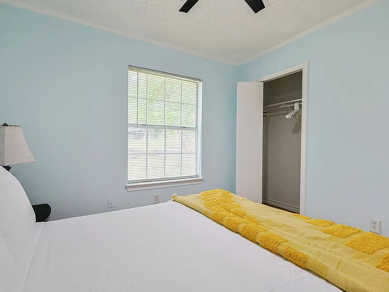 Bedroom 2 - a queen bed with a large window allowing lots of light into the room.