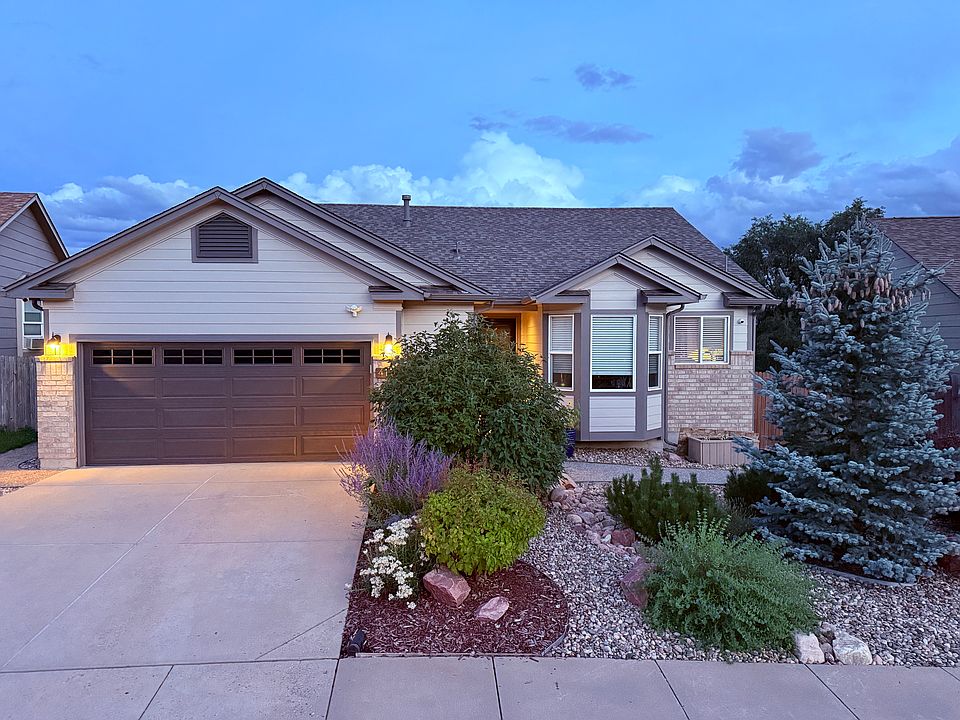 Beautifully xeriscape front landscaping with automatic sprinklers.