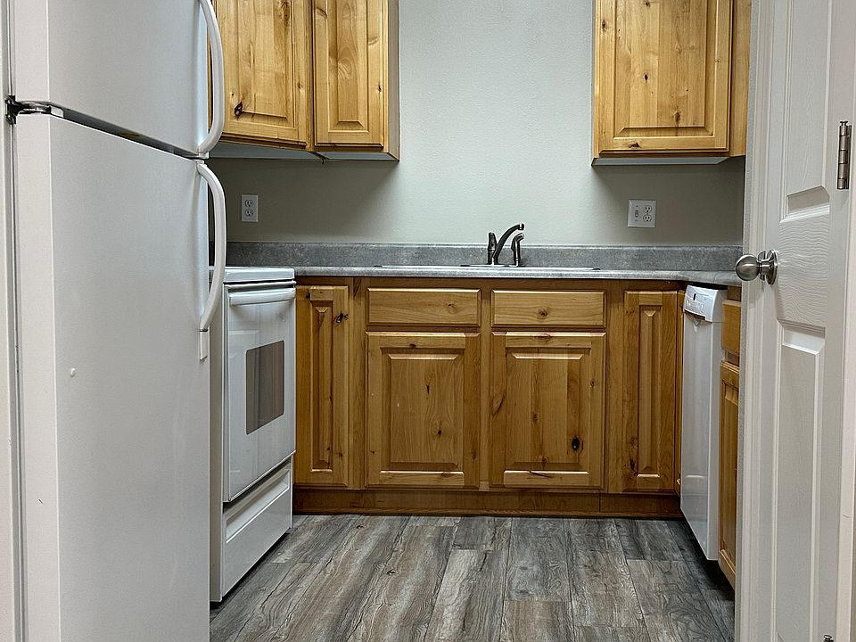Kitchen with refrigerator, microwave, dishwasher, oven, range, and lazy susan corner cabinets for extra storage.