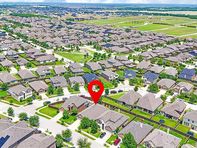 Aerial view of a residential neighborhood featuring numerous single-family homes with pitched roofs and green lawns