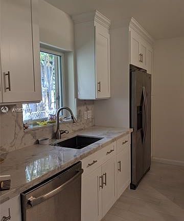 Notice the grain of Breccia Perl Soft Quartzite follows from the counter-top on to the full wall backsplash under the cabinets. See the Sunny kitchen window???