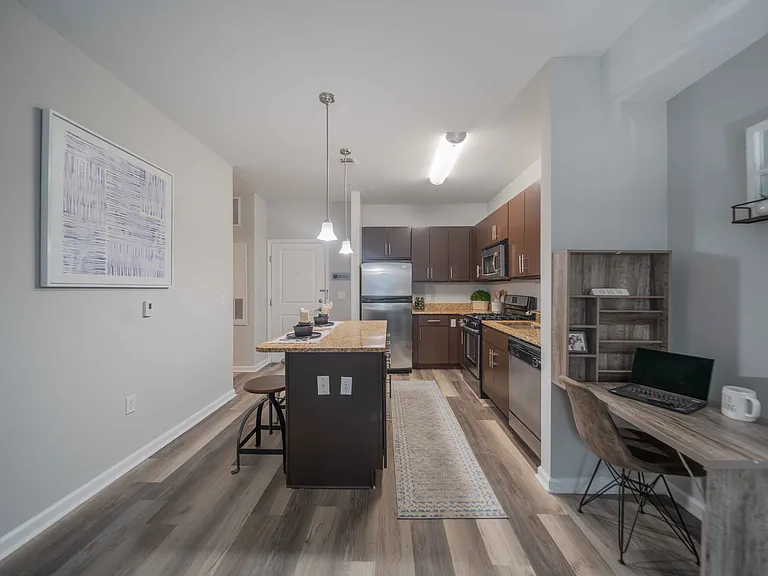 a kitchen with wooden cabinets and granite countertops at Harbor Pointe in Bayonne, NJ