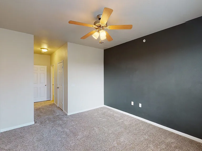 Spacious apartment bedroom with plush carpet flooring.