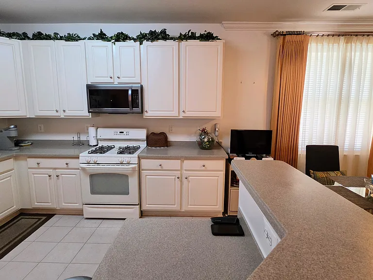 Bright, timeless white cabinetry paired with modern appliances, a gas range, and abundant countertop workspace.