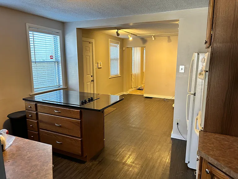 Kitchen has large island with cooktop, opens into dining room / flex space. Door shown is side entry door.