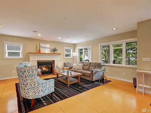 Inviting living room with lots of natural light, gorgeous custom millwork mantle with gas fireplace and wood wrapped windows.