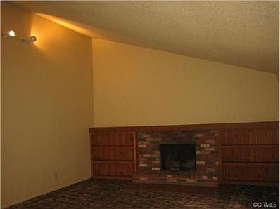 Living room with vaulted ceiling and wood burning fireplace.