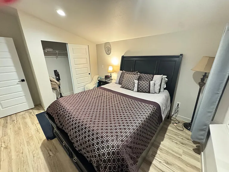Primary bedroom with closet, Smart TV, Laundry basket and portable vacuum