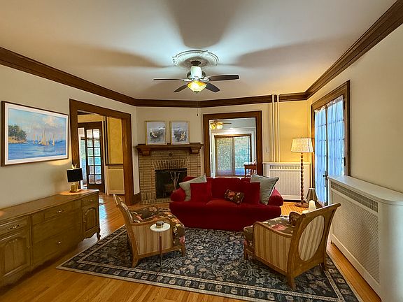 Large living area is flooded with light and features a working fireplace, flat screen TV and high end antique furnishings.