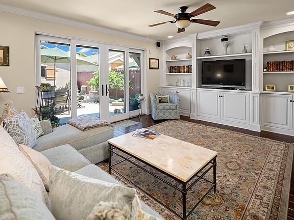 Family Room with TV opens to back yard with BBQ, Fire Pit, water feature and outdoor dining table