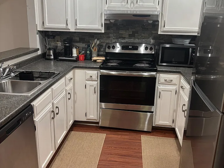 Efficient U-shaped kitchen with ample cabinet storage, durable countertops, and stainless steel appliances for everyday cooki