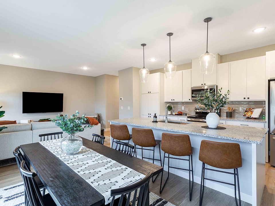 Contemporary open-plan living space featuring a stylish kitchen with modern appliances and a cozy dining area, perfect for entertaining.