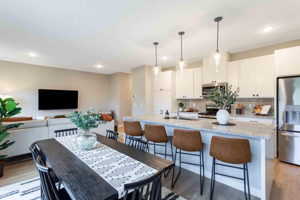 Contemporary open-plan living space featuring a stylish kitchen with modern appliances and a cozy dining area, perfect for entertaining.