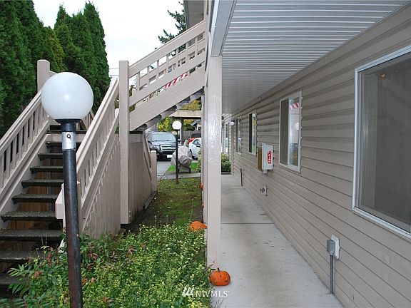 Nice covered walkway. Entrance screened by trees. Note concrete treads on stout stairway. 