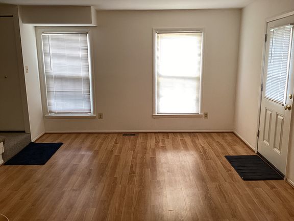 Living Room (15 feet x13 feet) with pergo flooring. Entry door to the right. Two windows in front wall of house provides natural lighting.