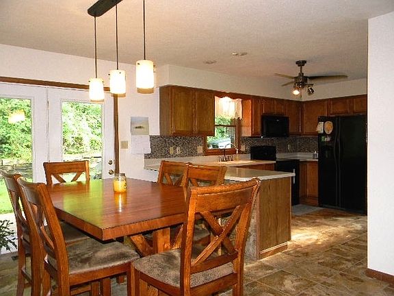 Updated Kitchen with Corian countertops, tiled floors, Goose neck faucet and underlay sink