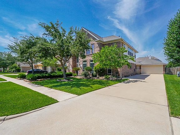 Mature trees and double wide driveway with detached garage.