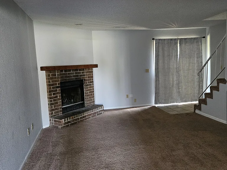 Living room showing fireplace and sliding door for patio