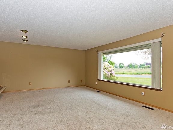 Large living room features a picture window that looks out to both mountain, sunrise & sunset views
