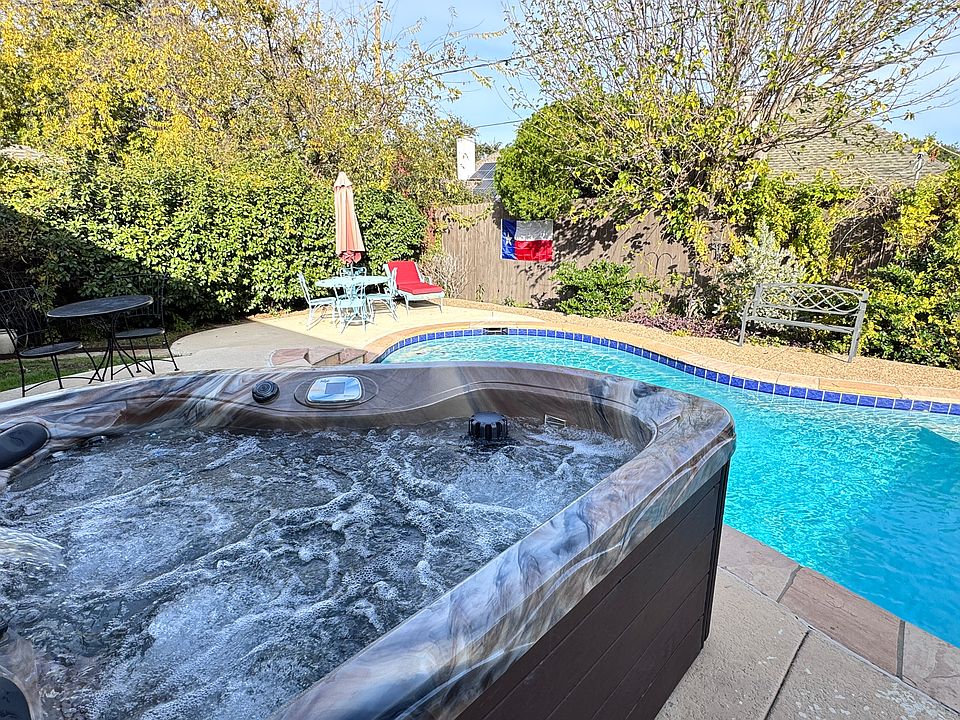 Therapeutic hot tub and sparkling pool make this backyard feel like a private oasis.