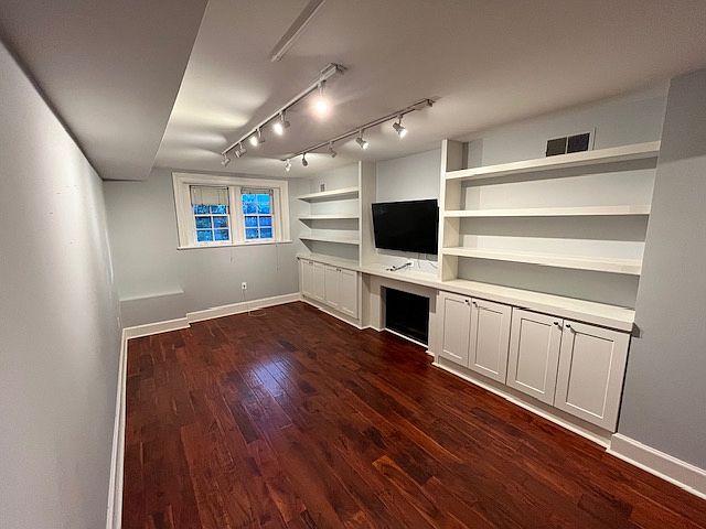 Living room with built in storage and mounted TV that comes with the rental