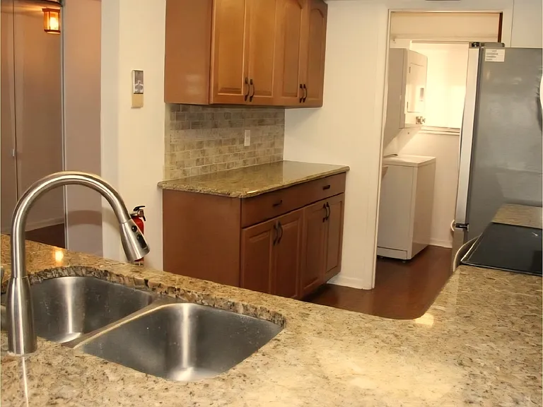 Kitchen connects to laundry room/storage area. The stacking washer/dryer have been replaced with new stacking washer/dryer stainless steel LG appliances.