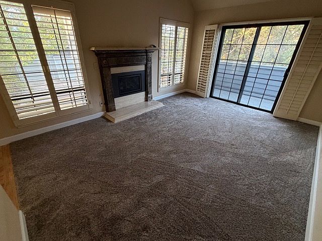 Large Living Room with gas fireplace and sliding glass door to outside deck area.