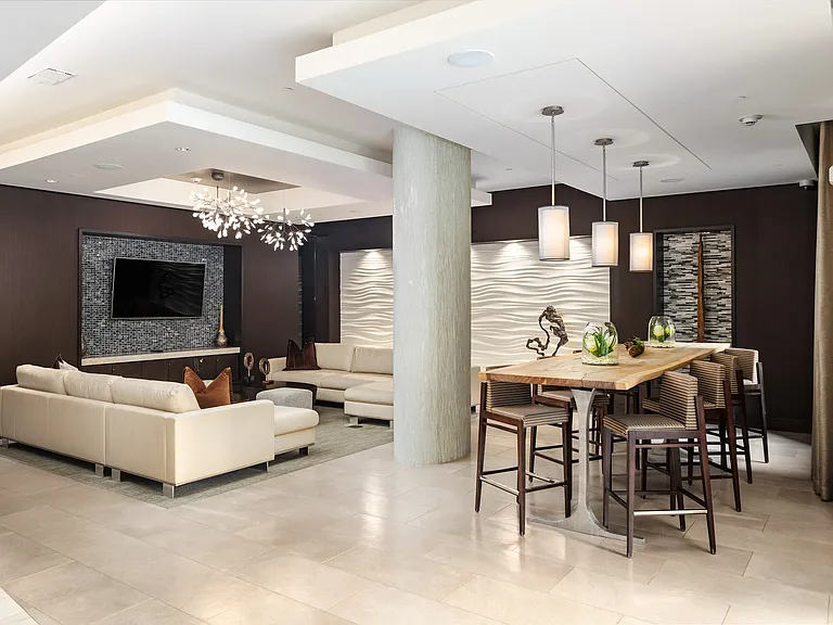 Resident Club Room Featuring TV, Lounge Seating, and Modern Pendant Lighting